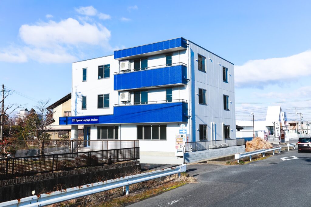 INC日本語学院の外観。青と白を基調とした3階建ての校舎。